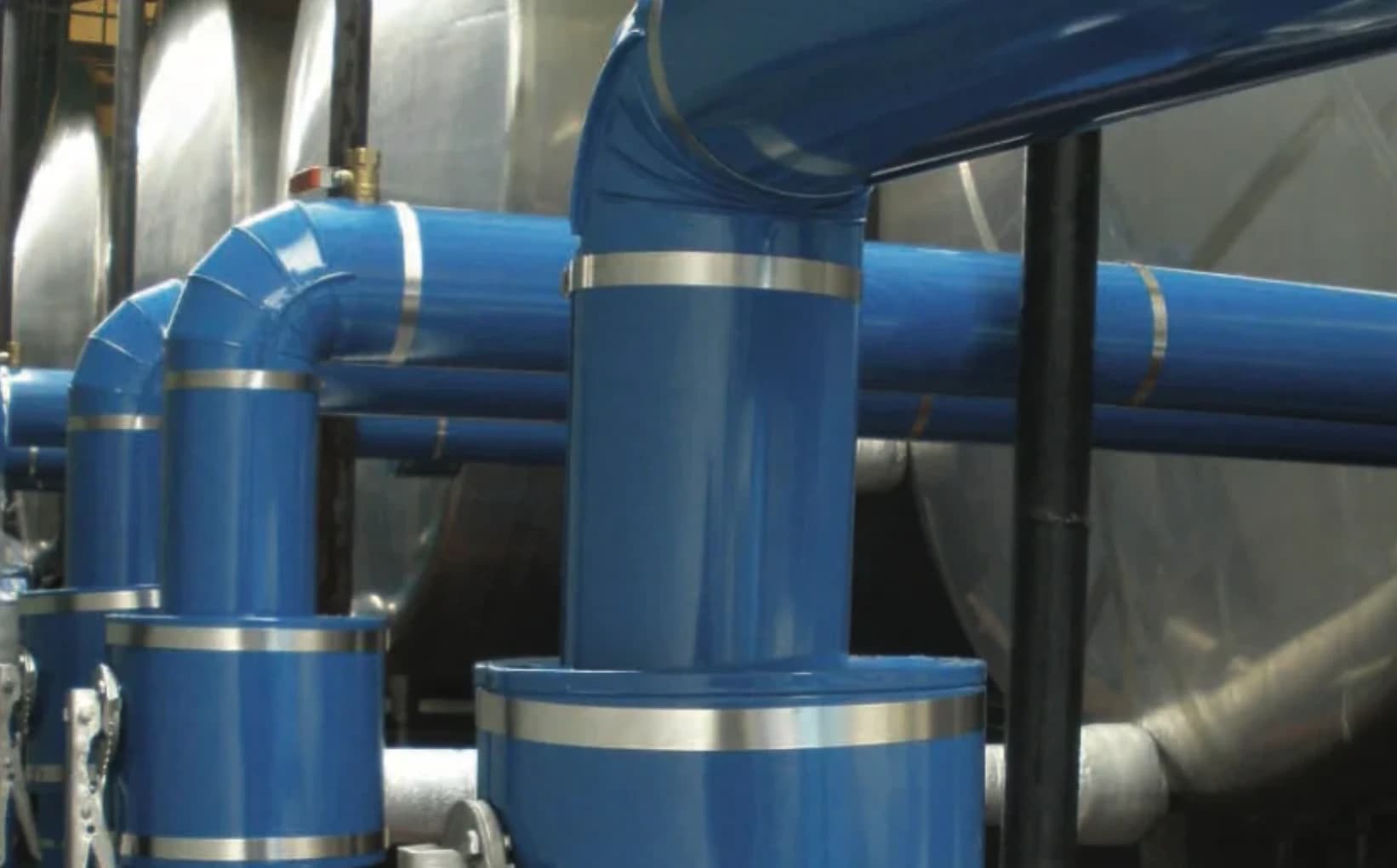 Stainless steel ClickClad bands installed across blue industrial pipe cladding